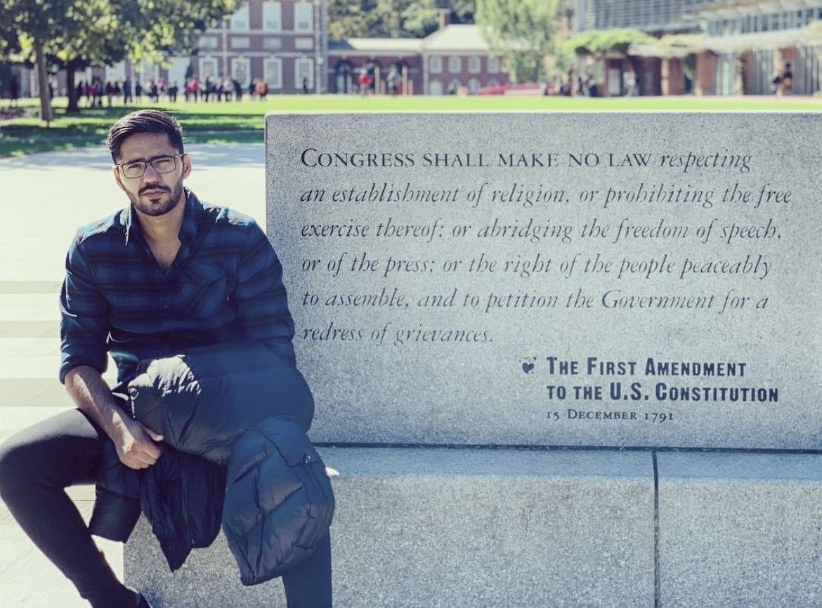 Faaiz sitting beside the First Amendment inscription