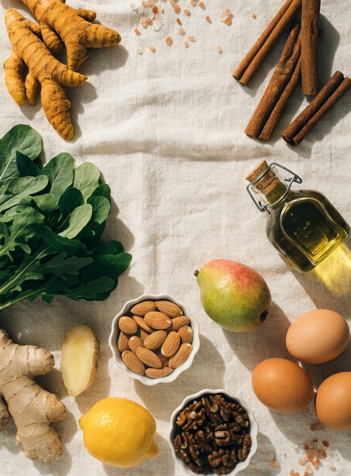 AI-generated flat-lay of turmeric, ginger, almonds and eggs on linen